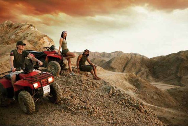Couple riding buggy safari in Sharm El Sheikh at sunset with desert landscape